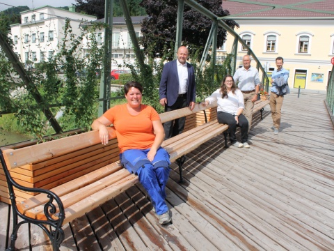 Fünf Personen sitzen und stehen bzw. sitzen auf der Töpperbrücke in der Stadt Scheibbs.