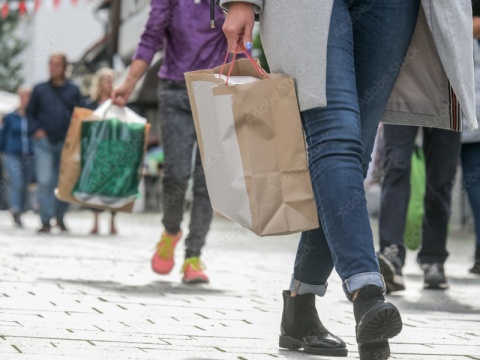 Personen mit Einkaufstaschen beim Gehen in der Einkaufsstraße.